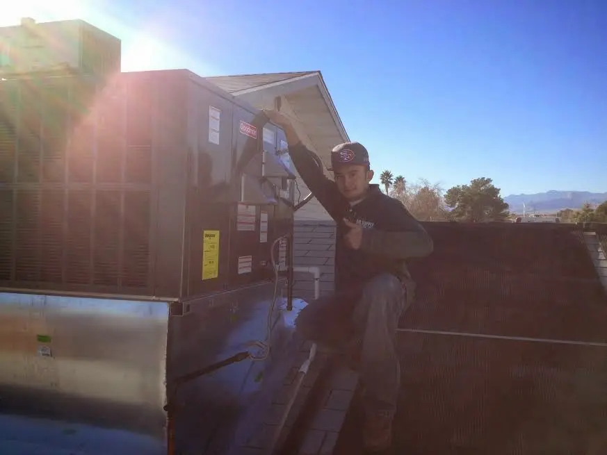 HVAC technician performing AC Tune-Up on a rooftop unit in Lynn Haven